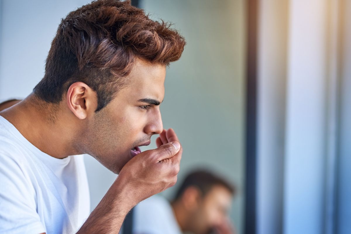 Man experiencing unpleasant breath caused by dental issues