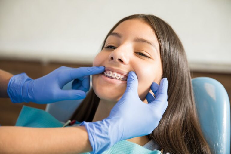 Orthodontist examining patient's braces during dental checkup in San Antonio.