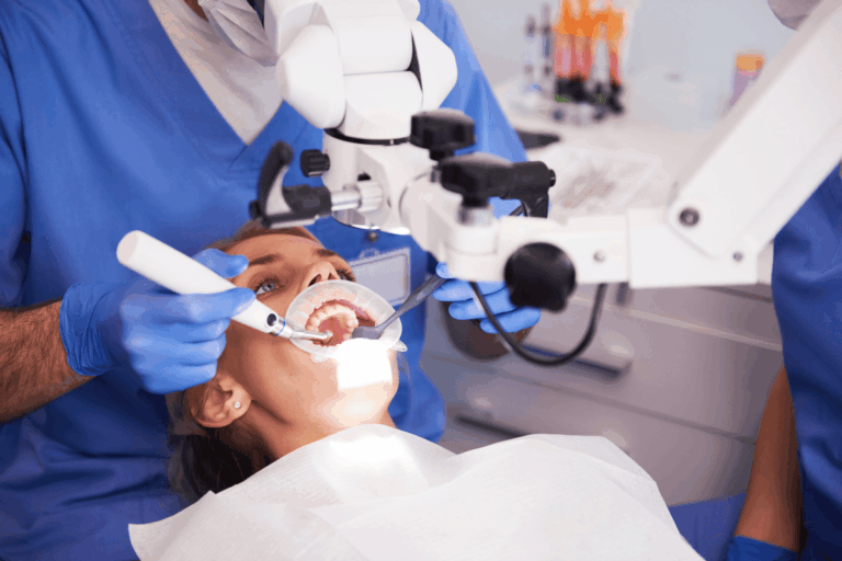 Dentist examining patient's teeth during family dental treatment in San Antonio.