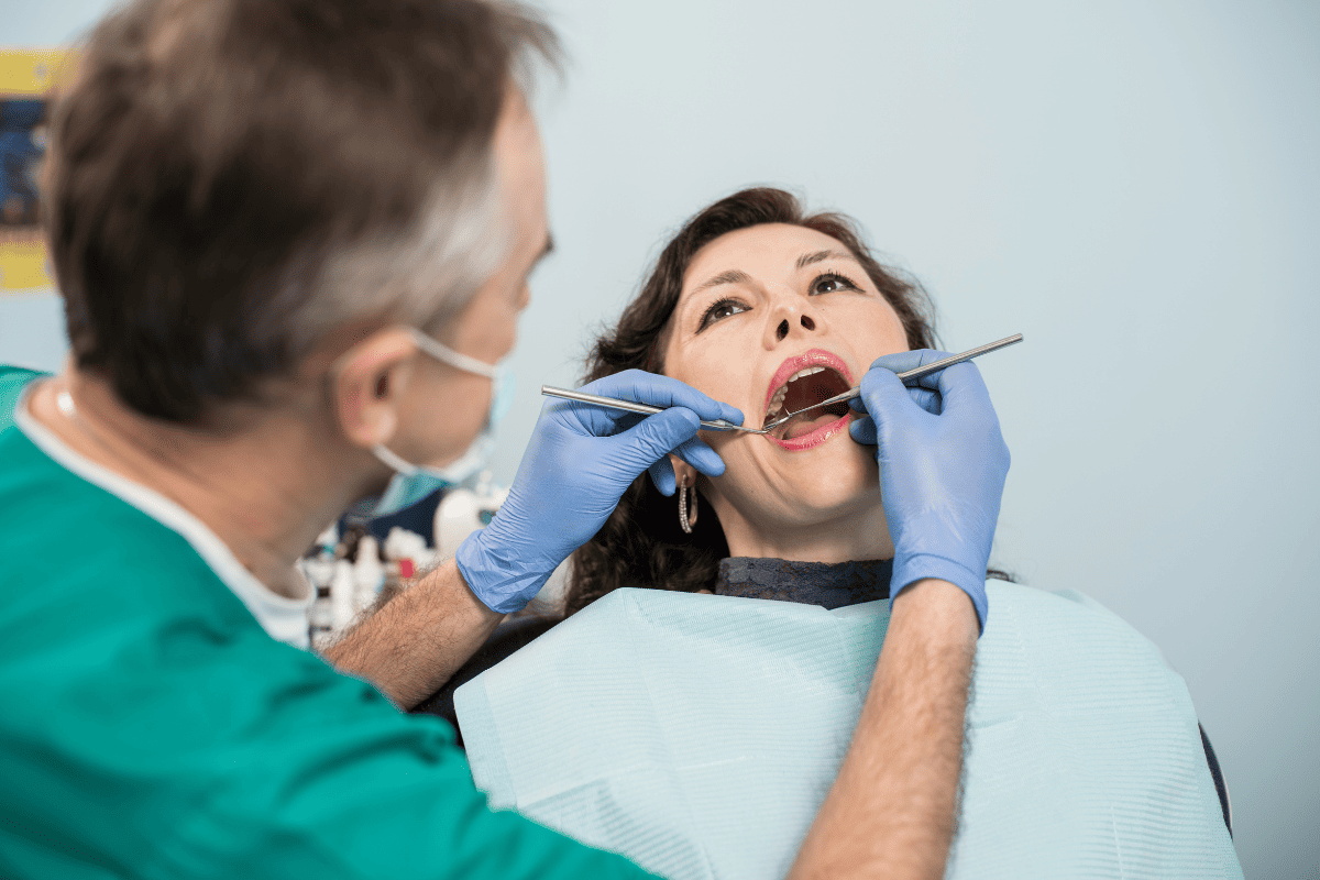 Dentist examining patient's teeth during dental checkup in San Antonio office.